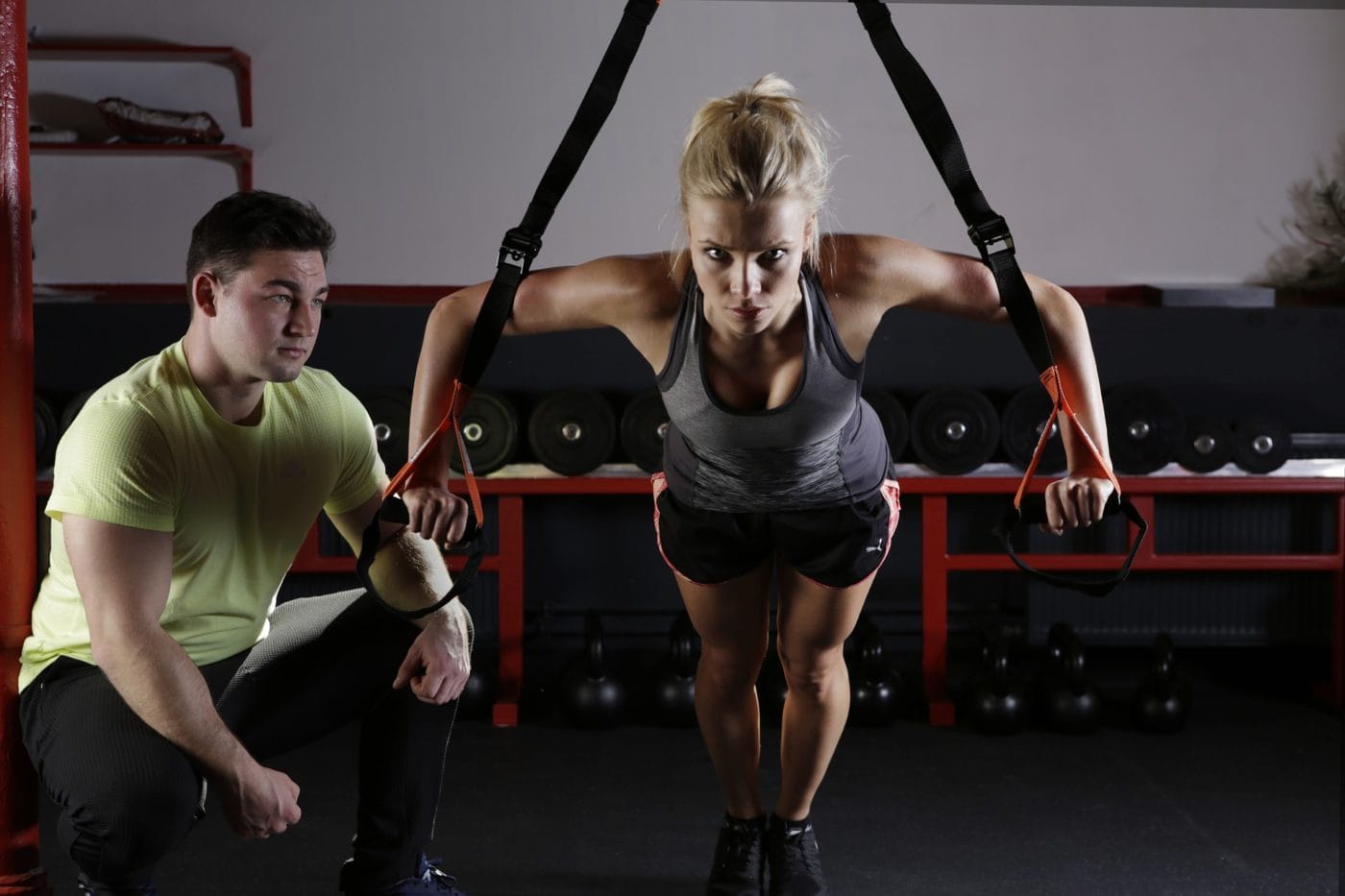 Woman working out being guided by trainer