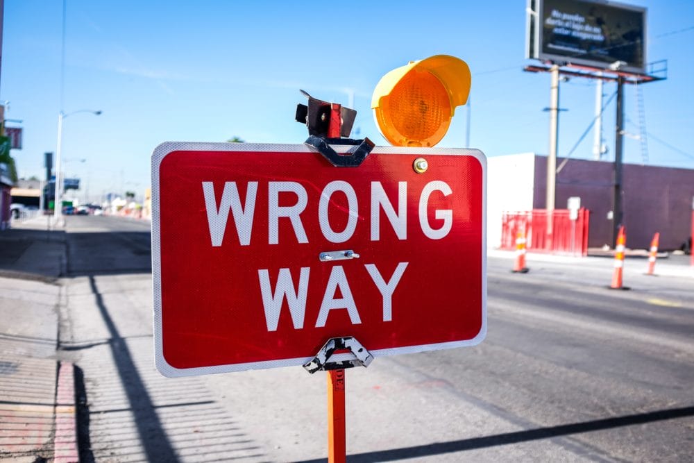 "wrong way" sign next to a road